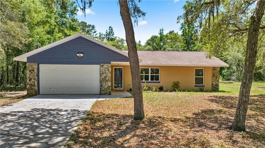 ranch-style house featuring stucco siding, an attached garage, stone siding, and concrete driveway