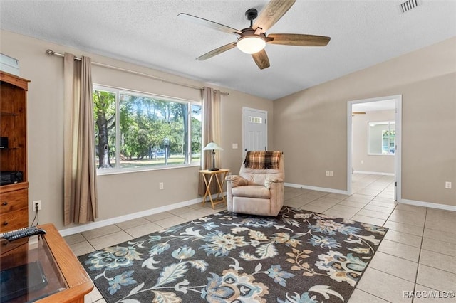 sitting room with light tile patterned floors, a textured ceiling, and ceiling fan