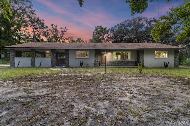 ranch-style home featuring a lawn