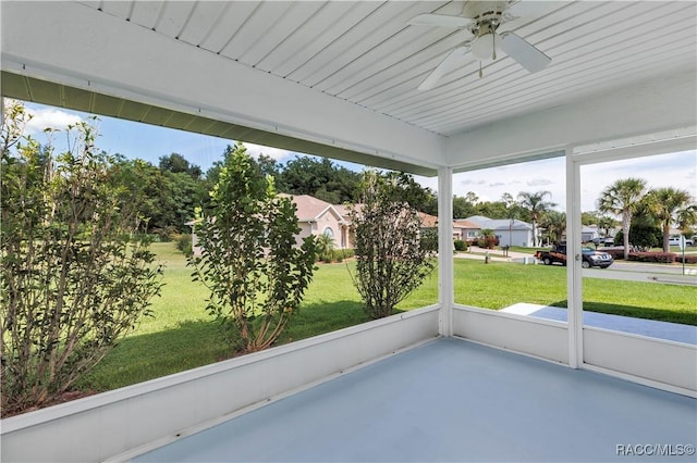 unfurnished sunroom featuring ceiling fan and plenty of natural light