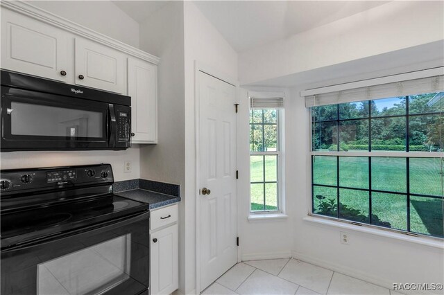 kitchen featuring white cabinetry, light tile patterned floors, and black appliances