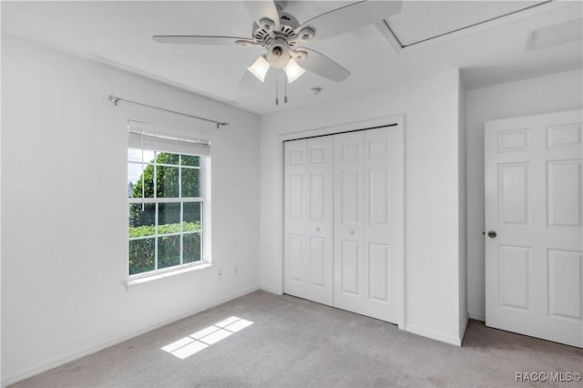 unfurnished bedroom with ceiling fan, a closet, and light colored carpet