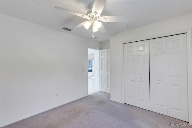 unfurnished bedroom with light carpet, a closet, and ceiling fan