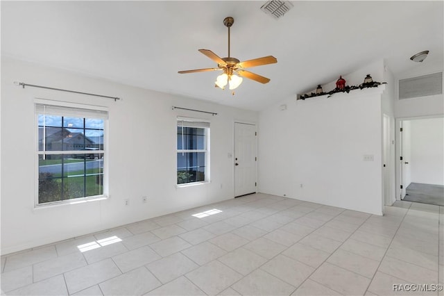 unfurnished room featuring ceiling fan, light tile patterned floors, and vaulted ceiling