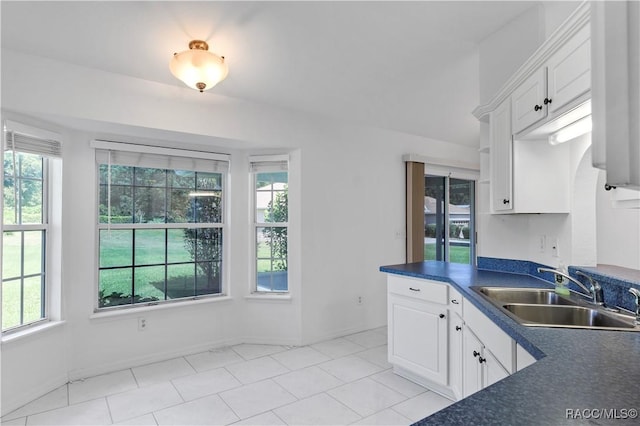 kitchen with sink, white cabinets, and light tile patterned flooring