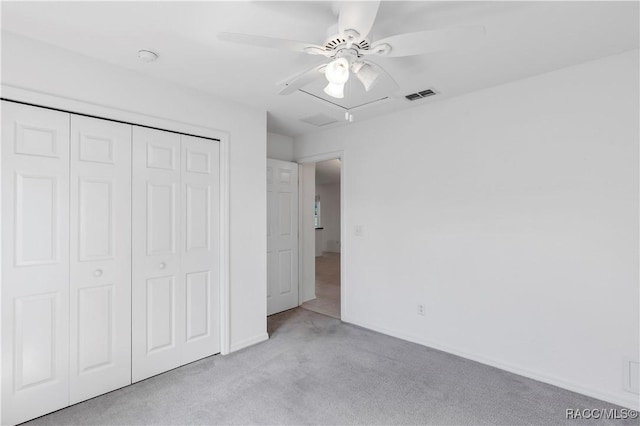 unfurnished bedroom with ceiling fan, light colored carpet, and a closet