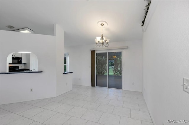 unfurnished room featuring a notable chandelier and light tile patterned flooring