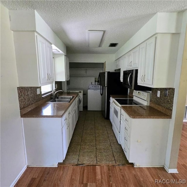 9227 N Fawn Way, Citrus Springs, FL 34434 - kitchen featuring electric stove, washer and dryer, dark countertops, white cabinets, and backsplash