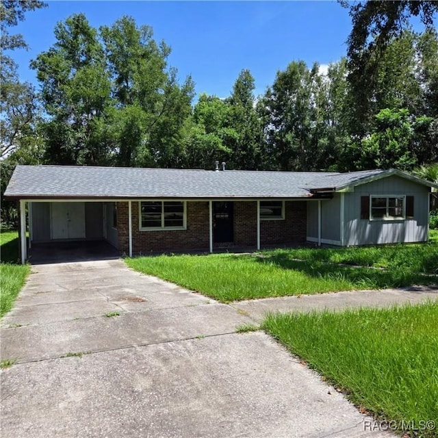 9227 N Fawn Way, Citrus Springs, FL 34434 - ranch-style house featuring driveway, an attached carport, a front lawn, and brick siding
