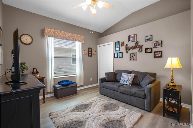 living area with ceiling fan, baseboards, vaulted ceiling, and light wood-style floors