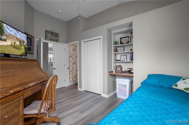 bedroom featuring wood finished floors, a closet, and baseboards