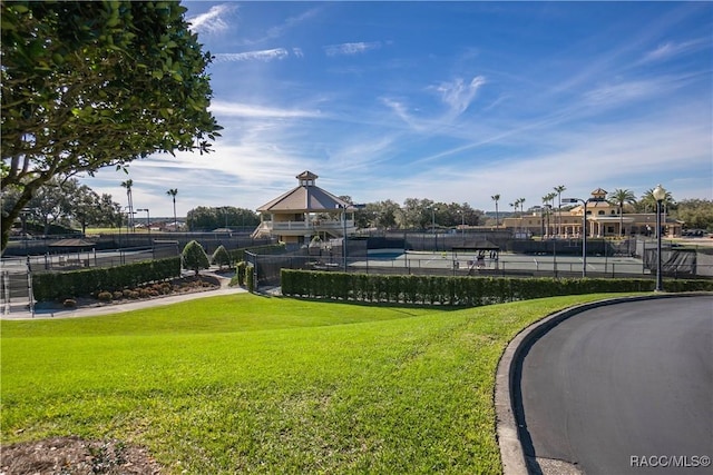 view of property's community with a lawn and fence
