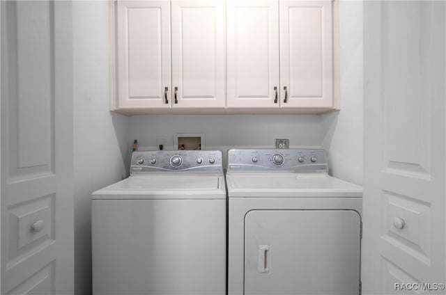 clothes washing area with cabinet space and washer and clothes dryer