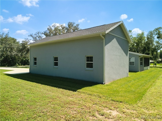 view of side of home with a yard