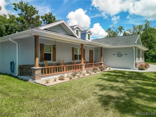 view of front of house with covered porch and a front lawn