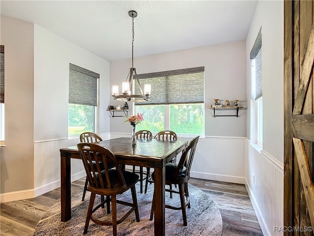 dining room with wooden walls, dark hardwood / wood-style floors, and a notable chandelier