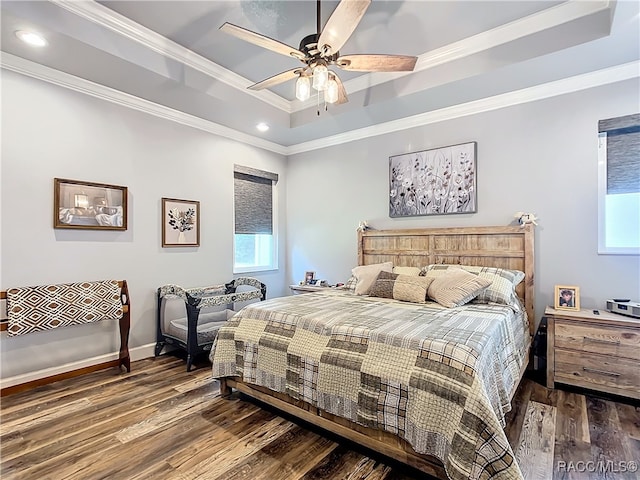 bedroom with a raised ceiling, ceiling fan, dark wood-type flooring, and crown molding