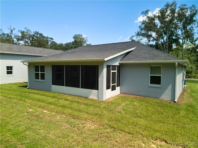 rear view of property with a lawn and a sunroom