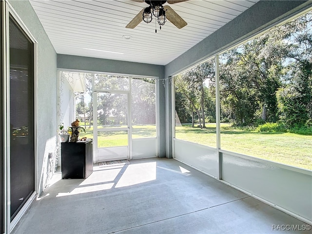 unfurnished sunroom featuring ceiling fan