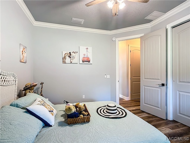 bedroom featuring a textured ceiling, ceiling fan, dark hardwood / wood-style floors, and crown molding