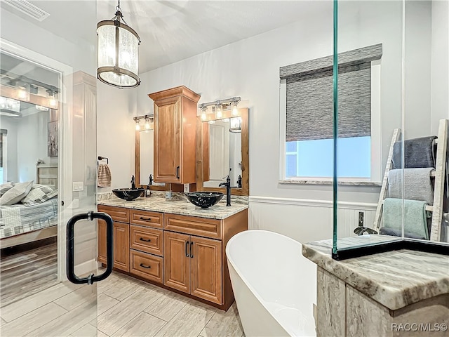 bathroom featuring a bathtub, vanity, an inviting chandelier, and hardwood / wood-style flooring