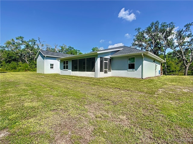 back of property featuring a lawn and a sunroom