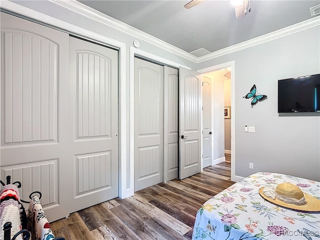 bedroom with dark hardwood / wood-style flooring, ceiling fan, and crown molding