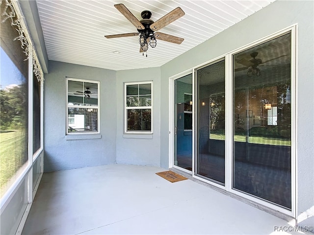 unfurnished sunroom featuring ceiling fan