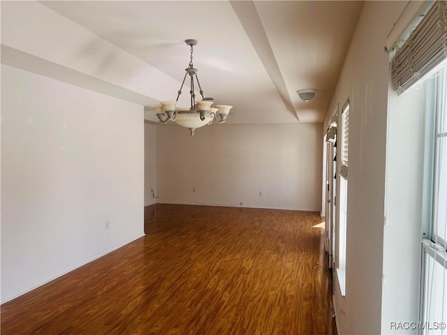 unfurnished room featuring hardwood / wood-style floors and a notable chandelier