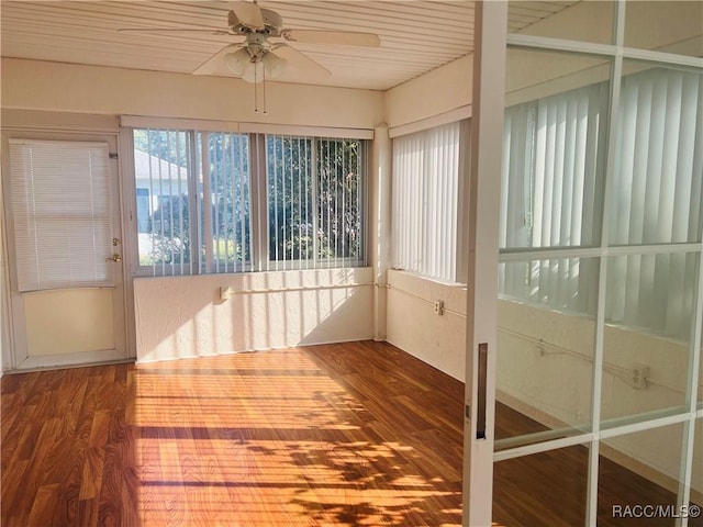 unfurnished sunroom with ceiling fan