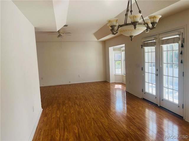 empty room featuring ceiling fan with notable chandelier, french doors, hardwood / wood-style floors, and a wealth of natural light