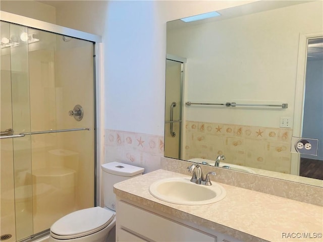 bathroom with an enclosed shower, vanity, and toilet