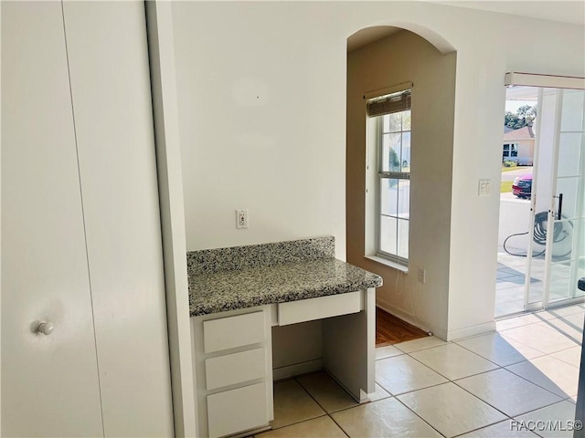 doorway with built in desk and light tile patterned flooring