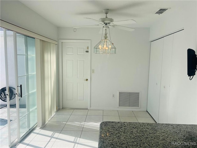 unfurnished dining area featuring ceiling fan and light tile patterned flooring