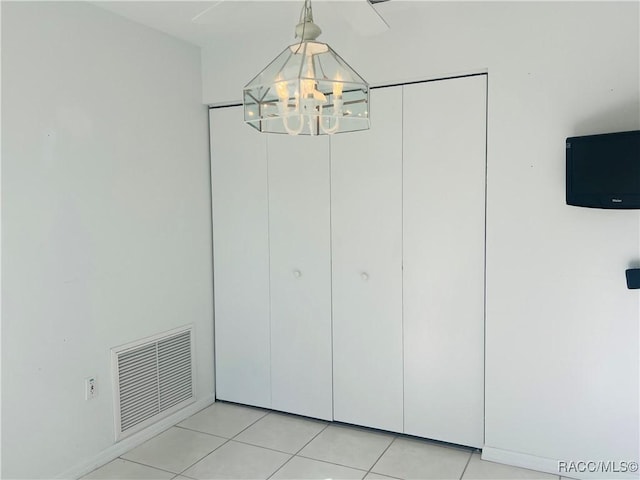 interior space featuring light tile patterned flooring and a chandelier