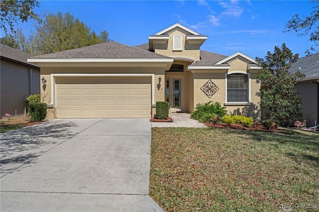 ranch-style home with a shingled roof, concrete driveway, an attached garage, a front lawn, and stucco siding