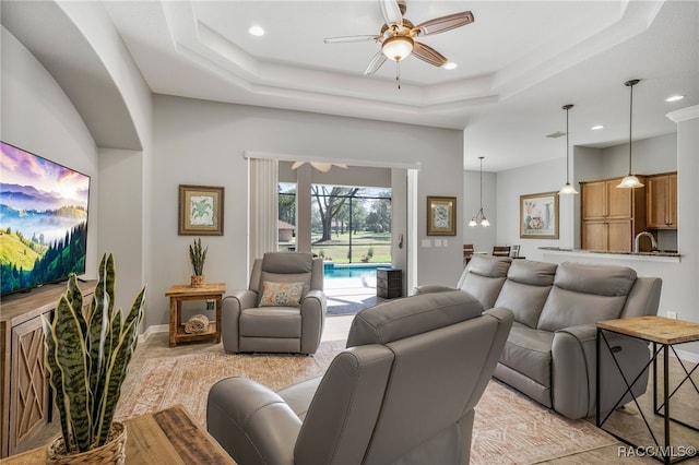 living room with recessed lighting, a raised ceiling, a ceiling fan, and baseboards