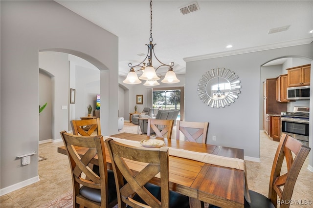 dining area featuring arched walkways, baseboards, visible vents, and crown molding