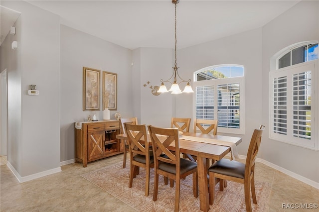 dining area with an inviting chandelier, light tile patterned floors, and baseboards