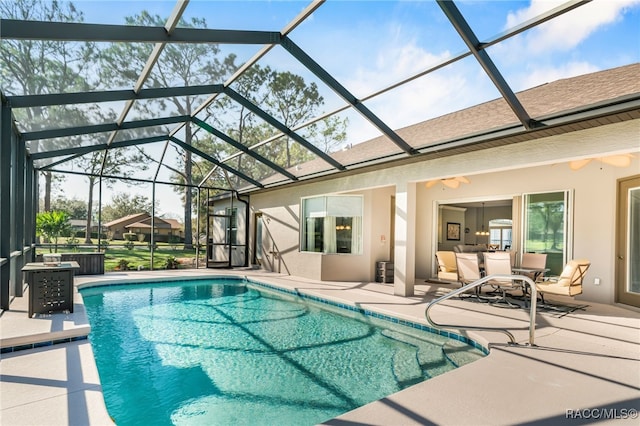 outdoor pool featuring glass enclosure and a patio