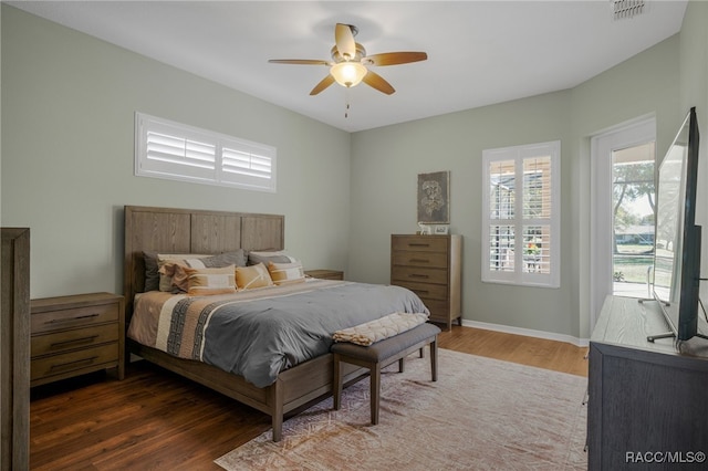 bedroom with visible vents, ceiling fan, baseboards, and wood finished floors