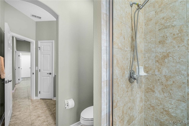 bathroom featuring visible vents, toilet, a stall shower, tile patterned flooring, and baseboards