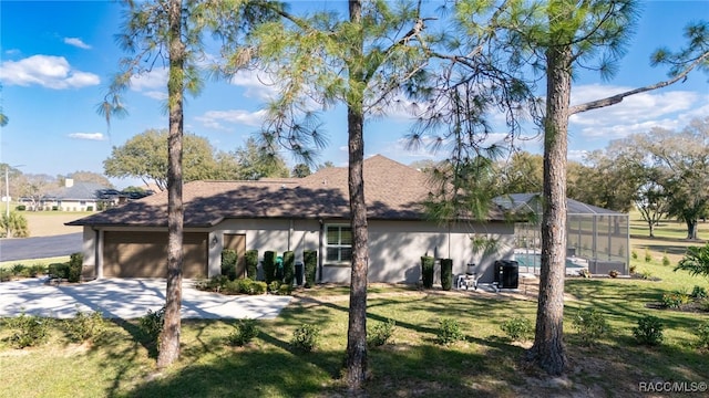 view of front of home featuring a garage, concrete driveway, a front lawn, and a lanai