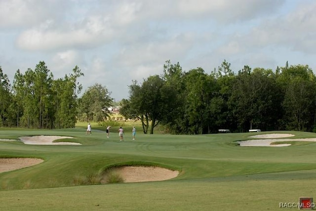 view of community with view of golf course and a yard