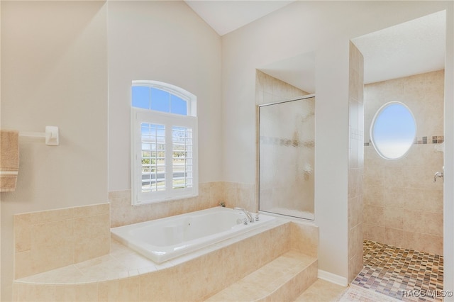 bathroom featuring tiled shower and a bath