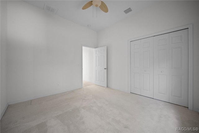 unfurnished bedroom featuring carpet, a closet, and a ceiling fan