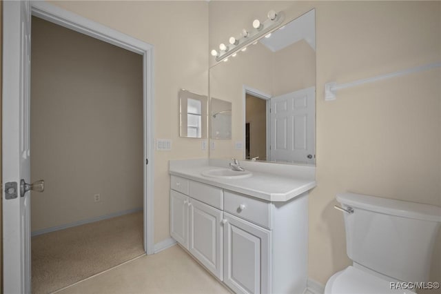 bathroom featuring toilet, vanity, and baseboards