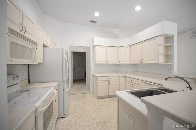 kitchen featuring white appliances, a sink, open shelves, light countertops, and recessed lighting