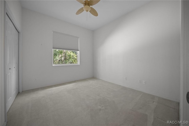 unfurnished bedroom featuring carpet floors, a closet, and a ceiling fan