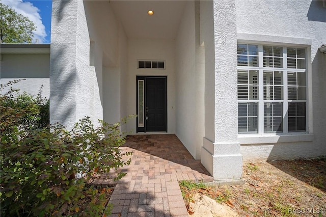 view of exterior entry with stucco siding